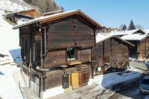 ein Holzhaus im Schnee mit Schnee in der Unterkunft Stadel Jäger in Reckingen - Gluringen