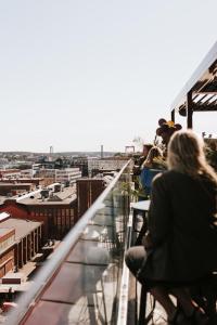 um grupo de pessoas sentadas numa varanda com vista para a cidade em Clarion Hotel The Pier em Gotemburgo