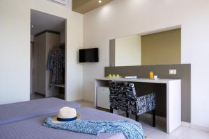 a bedroom with a bed and a desk with a hat on it at Cathrin Hotel in Faliraki