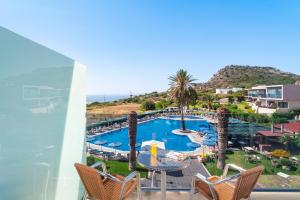een balkon met uitzicht op het zwembad van een resort bij Cathrin Hotel in Faliraki