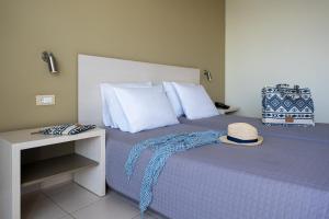 a bedroom with a bed with a hat on it at Cathrin Hotel in Faliraki