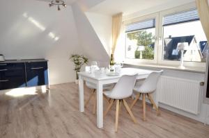 une cuisine blanche avec une table et des chaises blanches dans l'établissement Wohnung-Jan, à Westerland