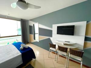 a bedroom with a bed and a tv on a wall at Loft Prainha Vista Mar in Arraial do Cabo
