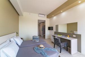 a bedroom with a bed and a desk with a hat on it at Cathrin Hotel in Faliraki