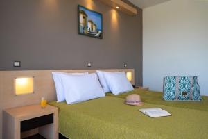 a hotel room with a bed with a green bedspread at Cathrin Hotel in Faliraki