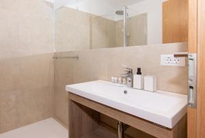 La salle de bains est pourvue d'un lavabo blanc et d'une douche. dans l'établissement The Best View House, à Piran