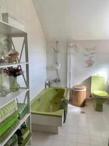 ein Badezimmer mit grüner Badewanne und WC in der Unterkunft Casa en Nigran amplia, cerca de la playa. in Nigrán