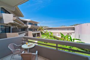 a balcony with a table and chairs and buildings at Cathrin Hotel in Faliraki