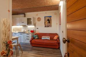 un salon avec un canapé rouge dans une cuisine dans l'établissement Affittacamere Il Bastione 27, à Volterra