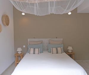 een slaapkamer met een groot wit bed met twee lampen bij Maison de vacances Villa Cardabella in Le Tignet +33 foto's