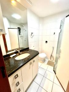 a bathroom with a sink and a shower and a toilet at Loft Prainha Vista Mar in Arraial do Cabo