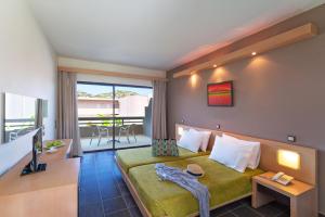 a hotel room with a bed and a balcony at Cathrin Hotel in Faliraki