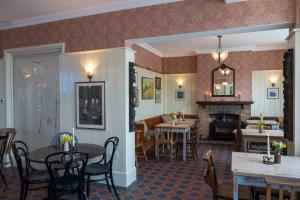 a dining room and living room with tables and a fireplace at Long Man Inn in Wilmington
