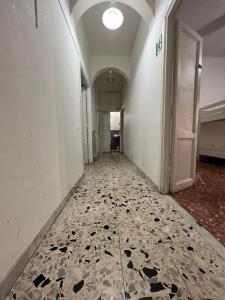 un corridoio vuoto con pavimento piastrellato in un edificio di MAGENTA GUEST HOUSE a Roma