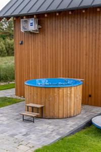 a hot tub with a bench next to a building at Kaszubska Lawenda Żuromino, Domek nr 3 in Żuromino