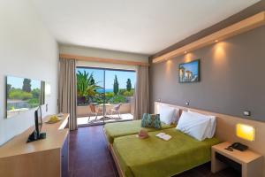 a hotel room with a green bed and a balcony at Cathrin Hotel in Faliraki