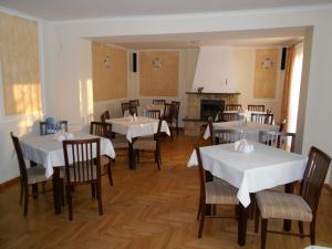 a dining room with tables and chairs and a fireplace at Willa Jan in Rewal