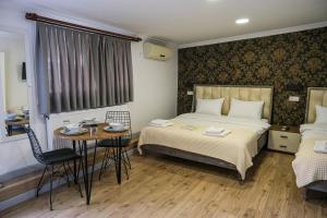 1 dormitorio con 1 cama, mesa y sillas en Taksim Neo Pera Suites, en Estambul