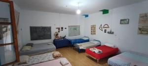 ein Wohnzimmer mit 2 Betten und einem Sofa in der Unterkunft Shkolla Hostel & Camping in Vuno