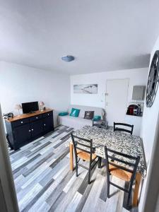 a living room with a table and chairs and a couch at SAINT GEORGES DE DIDONNE Baie de l océan les dauphins in Saint-Georges-de-Didonne