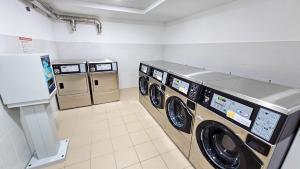 a laundry room with three washing machines in it at Aparthotel Codex in Rossano Stazione