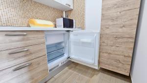 a kitchen with an open refrigerator and wooden cabinets at Aparthotel Codex in Rossano