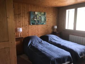 two beds in a room with wooden walls at Bernex(74) Appartement 4 personnes dans chalet vue imprenable in Bernex
