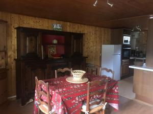 a kitchen with a table and a white refrigerator at Bernex(74) Appartement 4 personnes dans chalet vue imprenable in Bernex