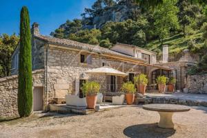 a stone house with a table in front of it at Superbe Mas Authentique du Luberon Courroussouvo in Oppède