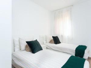 エル・メダノにあるLive Inglaterra Medano Beachの白い部屋のベッド2台 緑の枕付