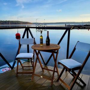 una mesa con 2 botellas de vino y 2 sillas en Apartament na wodzie Augustów en Augustów