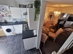 a kitchen with white cabinets and a dining room at Stunning 2-Bed House in Macclesfield Cheshire in Macclesfield