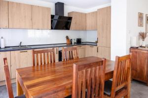 a kitchen with a wooden table and wooden chairs at Ferienwohnung`Akazie` mit Terrasse auf dem Bodanrück in Radolfzell am Bodensee +3 photos
