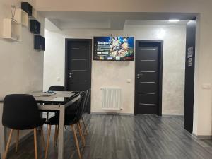 a dining room with black doors and a table and chairs at ARKADIA 2 BR APARTMENTs in Bucharest