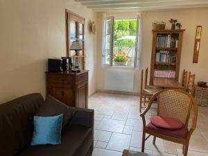 a living room with a couch and chairs and a window at Gite les Merlettes in Abbecourt