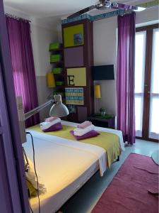カルマニョーラにあるB&B Binotのベッドルーム(紫色のカーテン付きのベッド1台付)