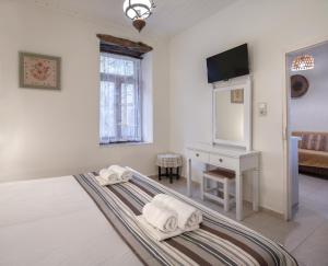 a bedroom with a bed and a tv and a mirror at Feneri- cozy Apartment 20' from Elafonisi beach in Perivólia