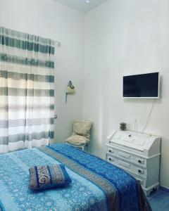 een slaapkamer met een bed, een dressoir en een televisie bij Acquamarina in Agropoli