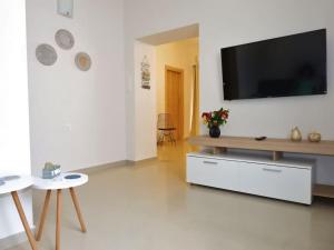 a living room with a flat screen tv on a white wall at Serene, slow living house in Orné