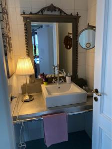 a bathroom with a sink and a lamp and a mirror at B&B Binot in Carmagnola