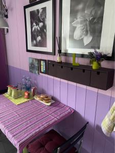 una habitación rosa con una mesa con comida. en B&B Binot, en Carmagnola