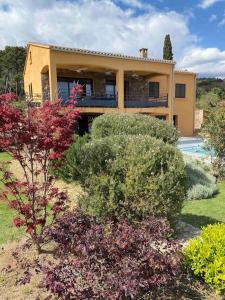 una casa con un montón de arbustos delante de ella en VILLA privée 3 étoiles avec piscine, jardin et terrain de pétanque en Lecci