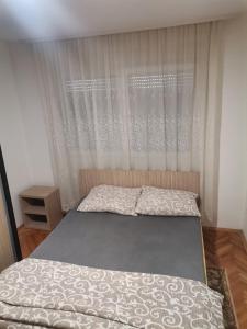 a small bedroom with a bed with a curtain at STAN na DAN PEX FREE PARKING in Vranje