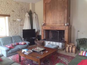 a living room with a couch and a fireplace at Maison ancienne avec piscine au milieu des vignes 