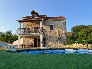 a house with a swimming pool in front of it at Stone House Chico in Ljubuški