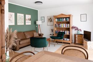 sala de estar con sofá y estante para libros en Ferienwohnung `Pinie` mit Terrasse auf dem Bodanrück, en Radolfzell am Bodensee