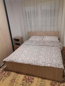 Dormitorio pequeño con cama con edredón blanco en STAN na DAN PEX FREE PARKING en Vranje