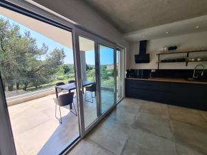 a kitchen and dining room with a table and sliding glass doors at Black & White in Pula