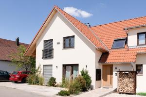 Casa blanca con techo rojo en Ferienwohnung `Pinie` mit Terrasse auf dem Bodanrück, en Radolfzell am Bodensee