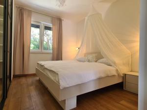 a bedroom with a bed with a mosquito net at Black & White - heated pool in Pula